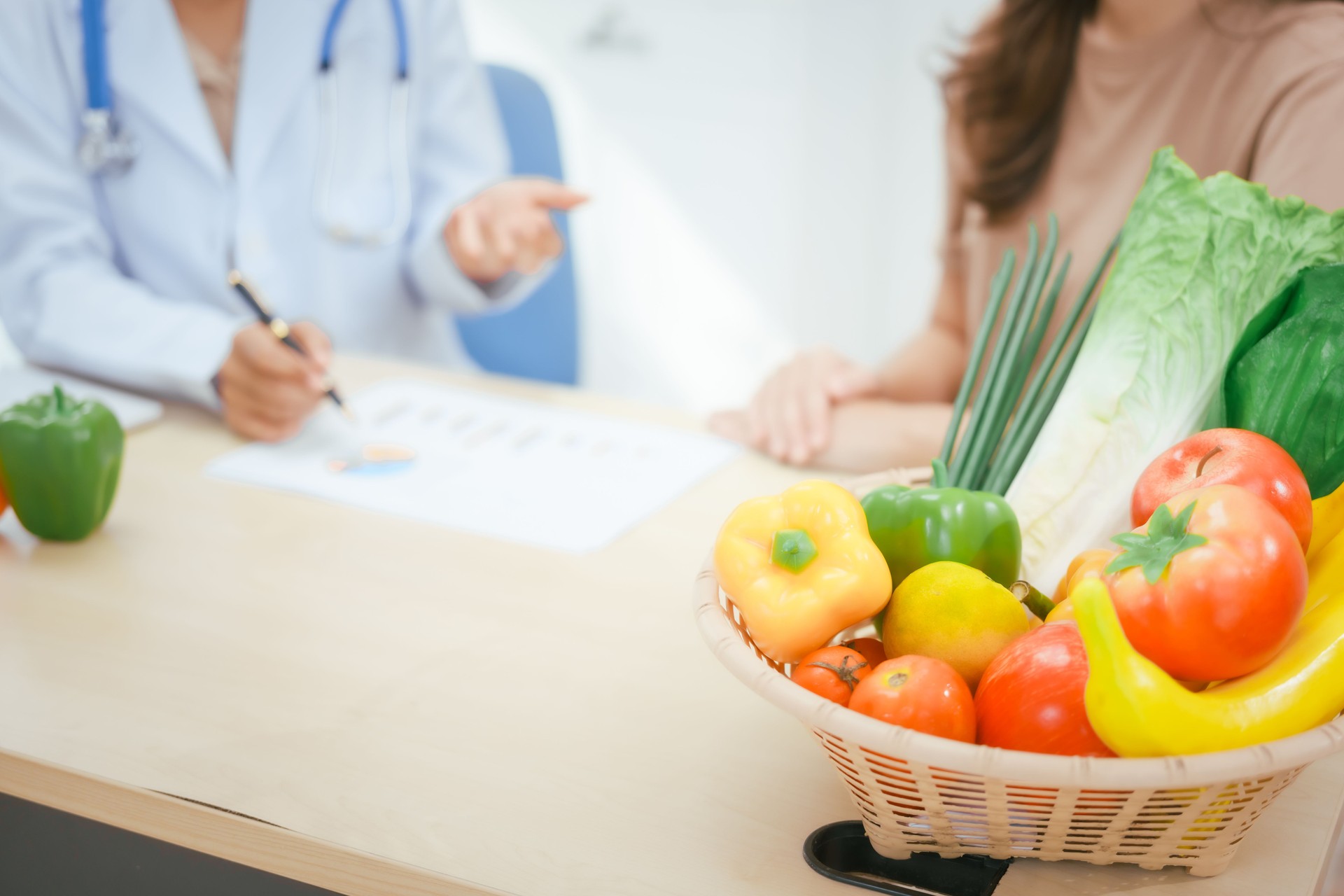 A young female nutritionist expert works at a hospital desk,consulting female patients about eating vegetables fruits, promoting a healthy diet,providing guidance for effective weight loss wellness